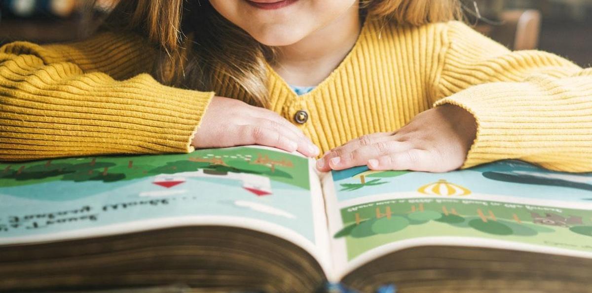 Una niña lee un libro.