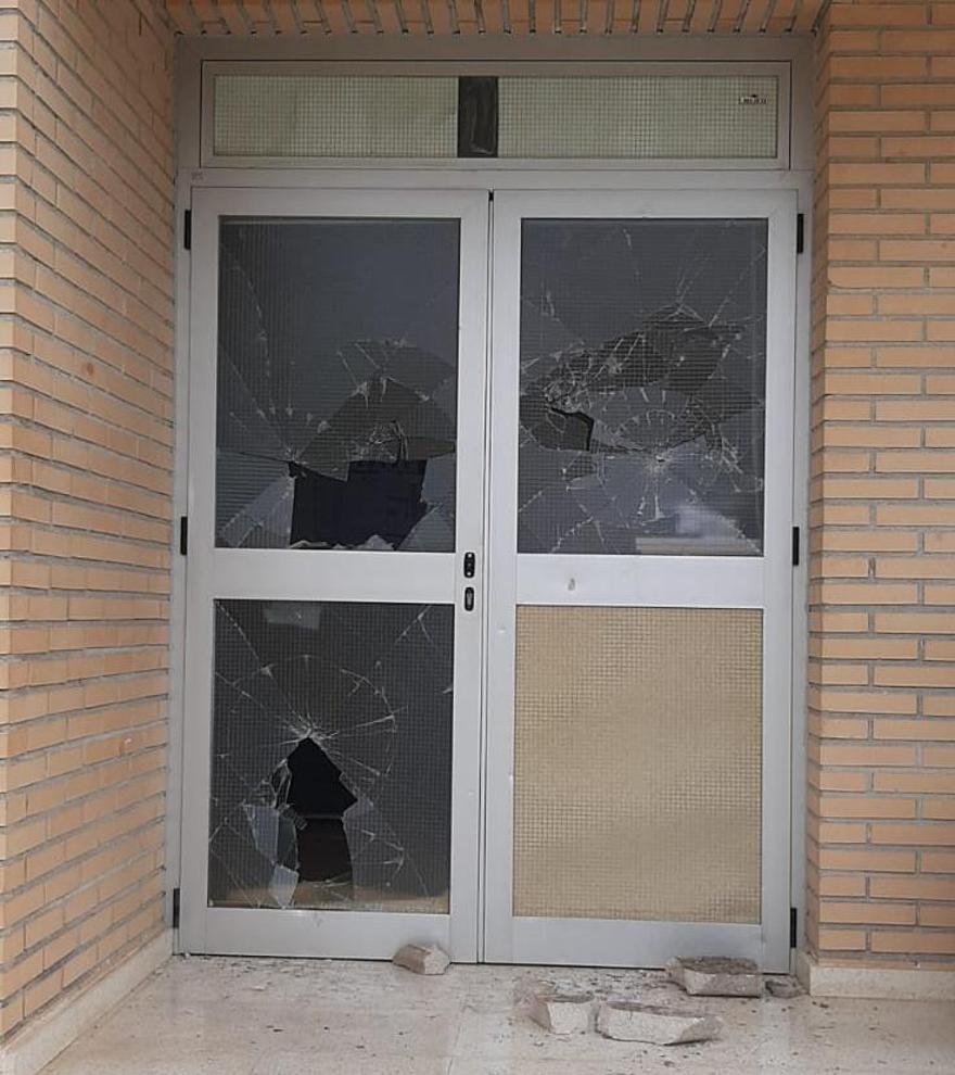 Una de las puertas del centro educativo reventada a pedradas.