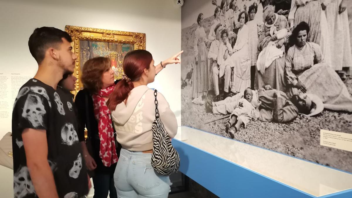 Integrants de la família Pichot admirant una fotografia de gran format on es veuen part dels seus avantpassats.