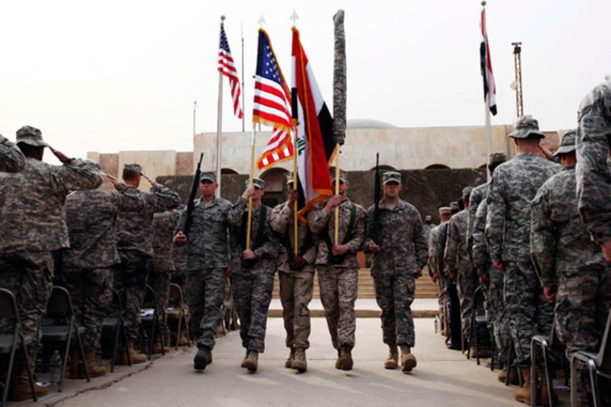 Membres de l’Exèrcit nord-americà porten banderes durant la cerimònia del final de la presència a l’Iraq, a Bagdad.