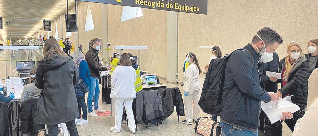 Pasajeros a su llegada en Son Sant Joan pasando el control de Sanidad Exterior.