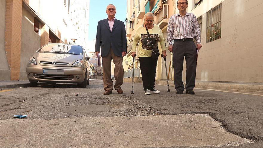 José Fernández (izquierda), Guillermina y Alberto Domínguez, ayer en un tramo de la deteriorada calle Mariscal.