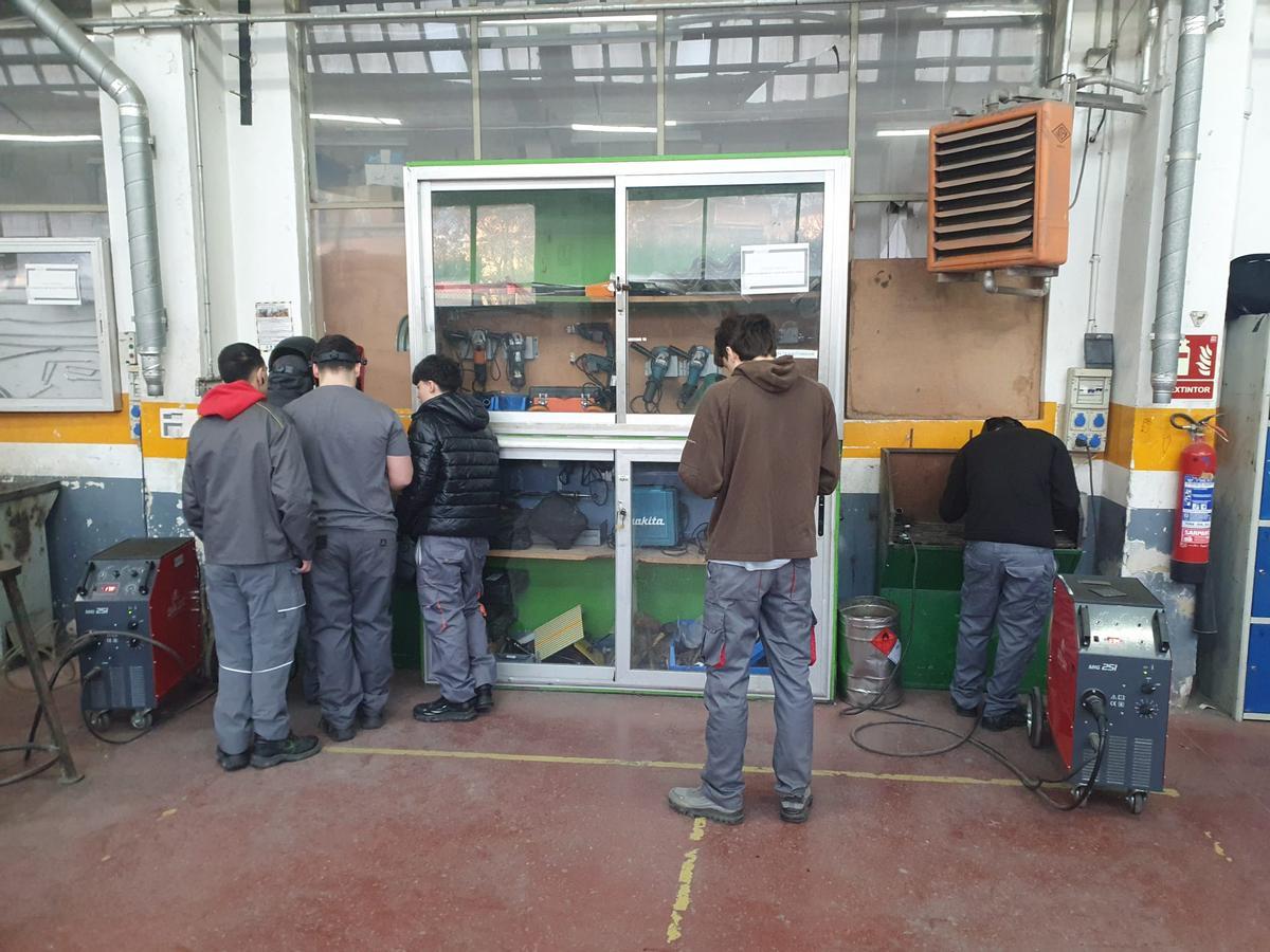 Varios alumnos trabajan abrigados en el taller de FP del Virgen del Pilar.