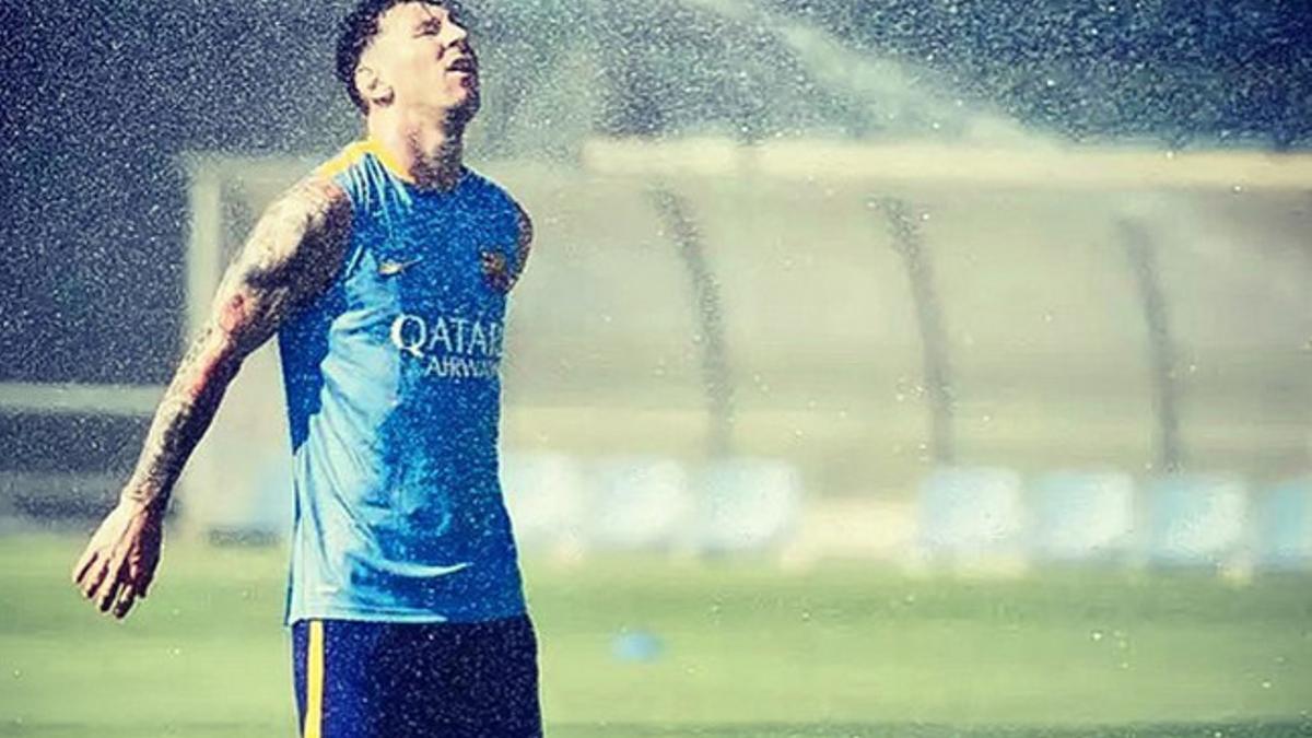 Leo Messi refrescándose con el agua de los aspersores en la Ciutat Esportiva