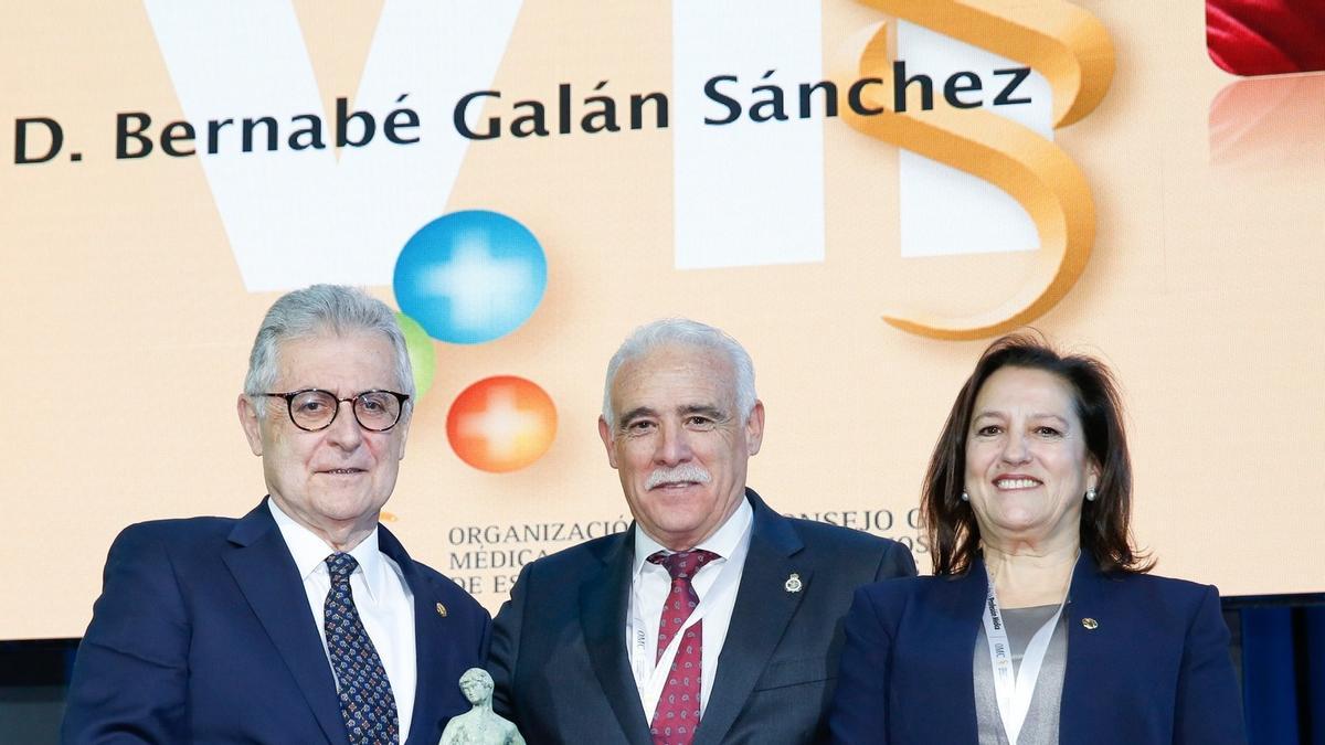 Bernabé Galán recibe el premio de Enrique Guilabert, en presencia de la presidenta del Colegio de Médicos de Córdoba, Carmen Arias.