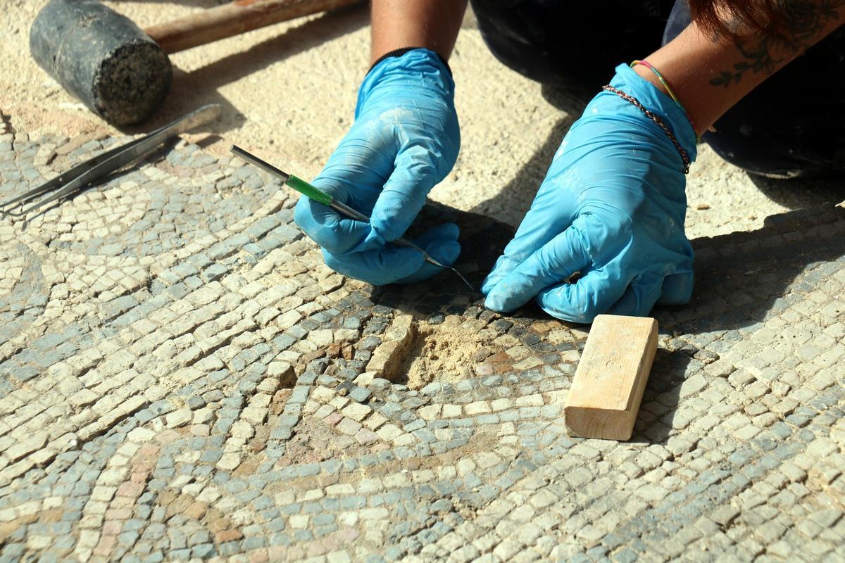 Detall d'un fragment del mosaic romà de la vil·la de Sarrià de Ter i com se l'està restituint amb tessel·les
