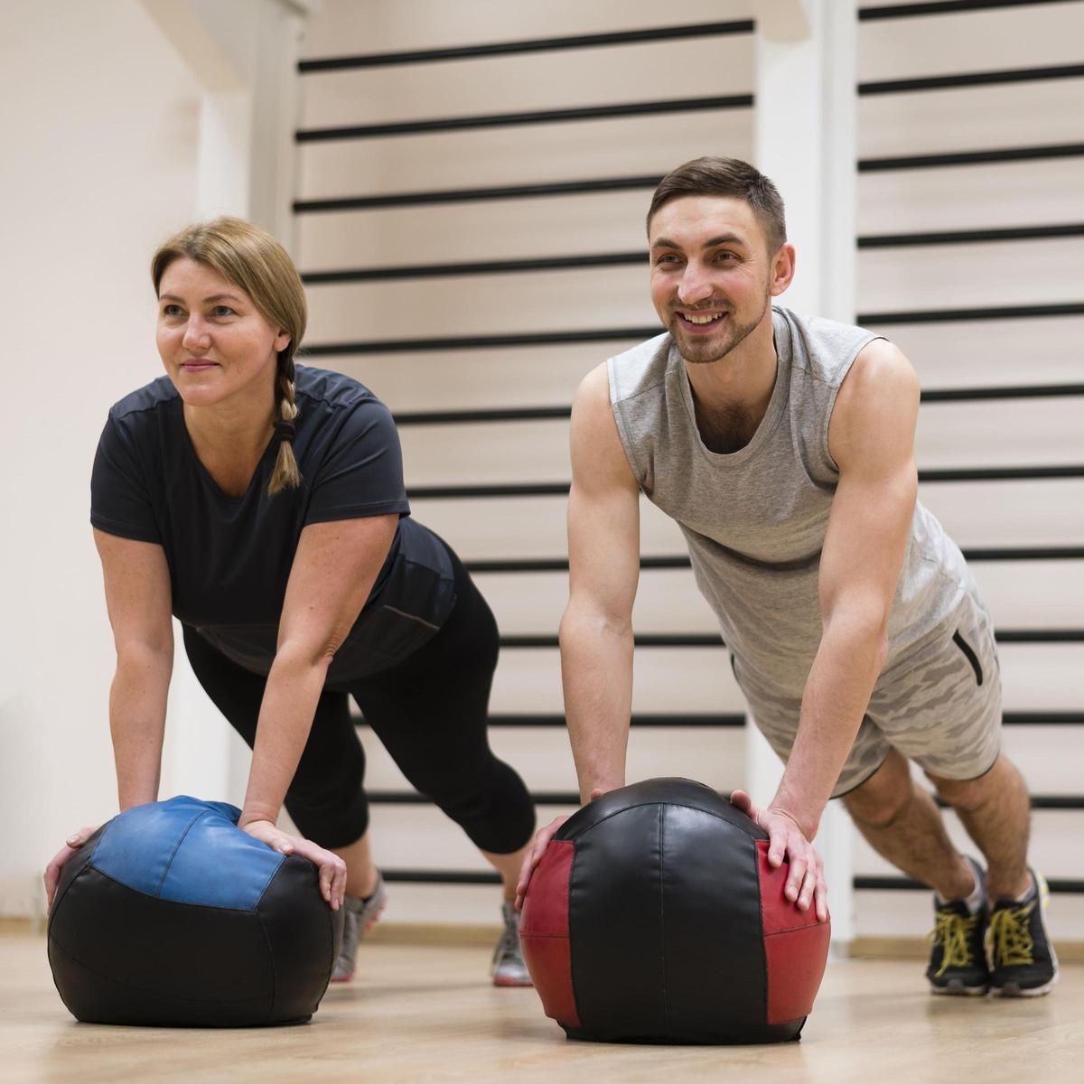 Entrenador personal imparte una clase junto a una alumna.