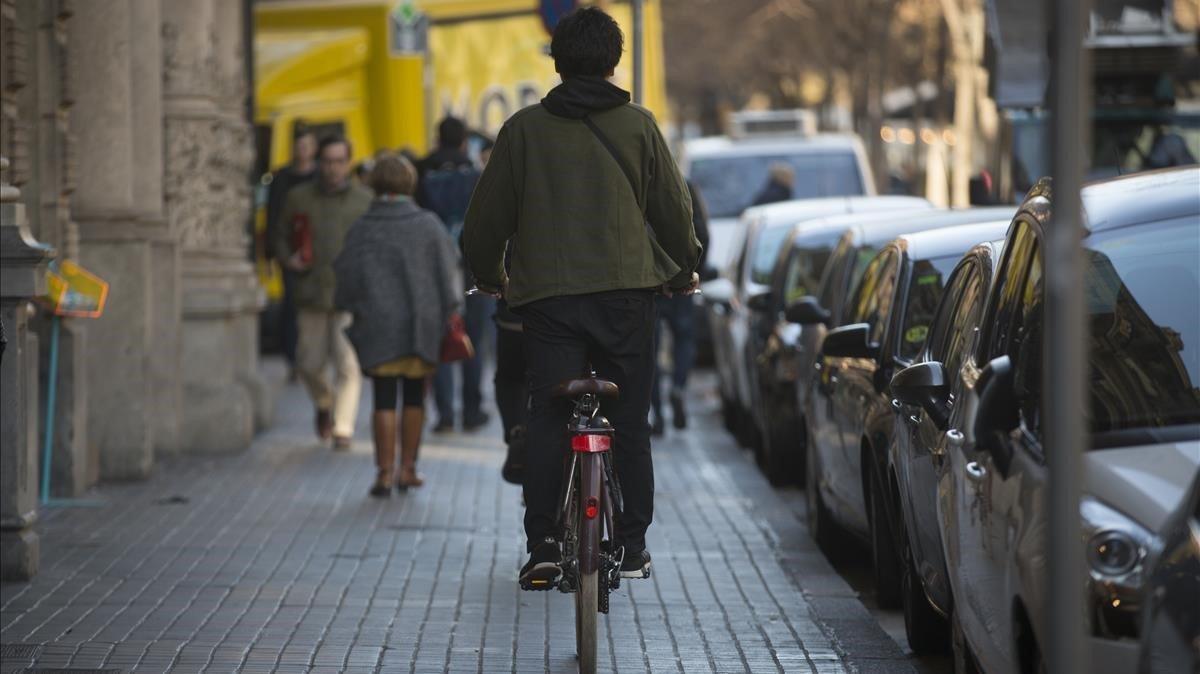 Un ciclista en la acera de la Rambla de Catalunya