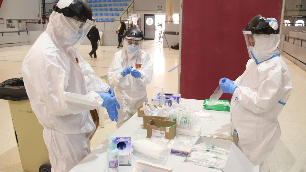 Tres sanitaris preparant el material per fer proves PCR en el cribratge massiu de Montblanc