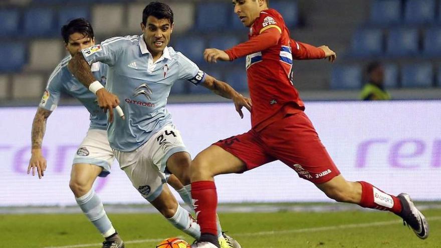 Augusto Fernández sale al paso a un rival durante el encuentro disputado ayer en Balaídos entre el Celta y el Espanyol. // Marta G. Brea