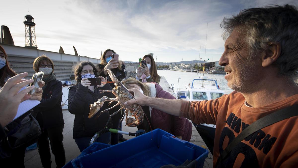 Rafa exhibe ante los móviles el bogavante recién pescado.