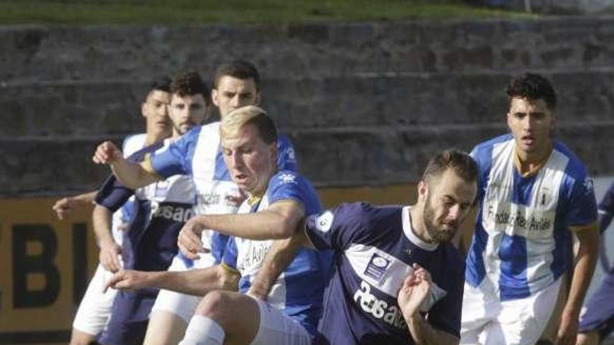 El jugador del Avilés Marcos, a la izquierda, lucha por un balón con Álvaro García, del Marino.