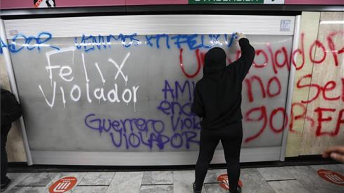 Una manifestante pinta un grafiti en una pared del sistema de transporte Metro contra Félix Salgado Macedonio,