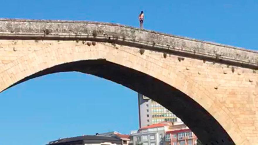 Un joven salta del Puente Romano de Ourense para bañarse en el río Miño