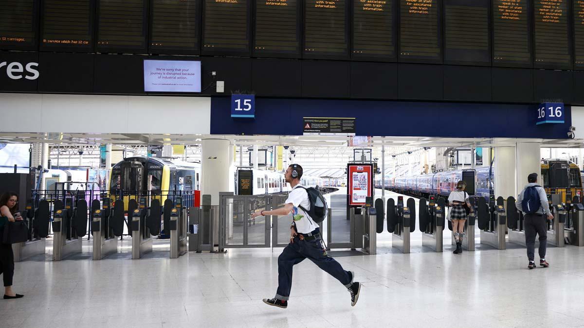 Un pasajero corre para tomar un tren en la estación de Waterloo antes de que el servicio de trenes termine temprano, en el primer día de la huelga ferroviaria nacional en Londres, Gran Bretaña, el 21 de junio de 2022. REUTERS/Henry Nicholls