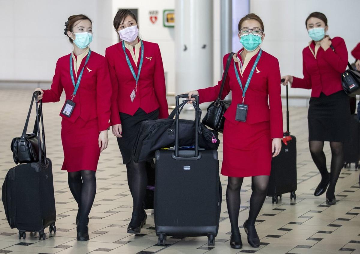 Brisbane (Australia), 30/01/2020.- Flight attendants wear protective face masks at Brisbane International Airport in Brisbane, Australia, 31 January 2020. Australia confirmed at least 9 cases of coronavirus, prompting the government to plan a much-criticized relocation plan for Wuhan evacuees to the remote Christmas Island for two weeks. The virus originated in the Chinese city of Wuhan and has so far killed at least 213 people, infecting over 8,000 others, mostly in China. EFE/EPA/GLENN HUNT AUSTRALIA AND NEW ZEALAND OUT