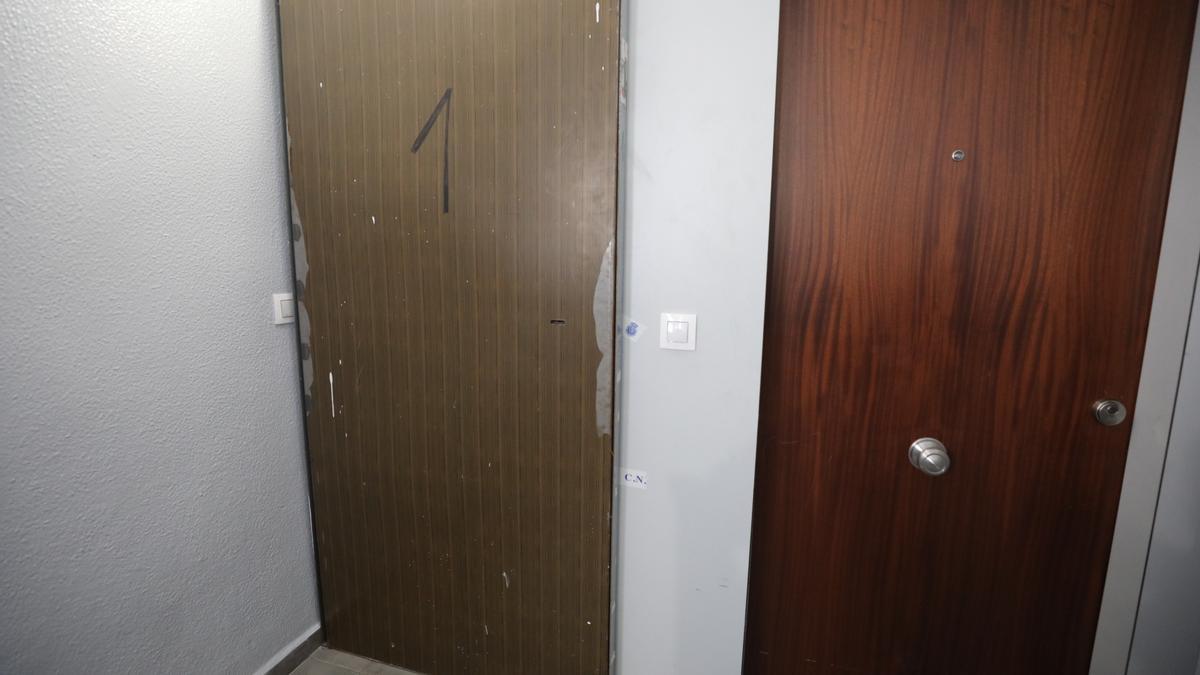 La puerta &quot;antiokupas&quot;, a la izquierda, colocada en la casa donde fue asesinada la joven en Elche.