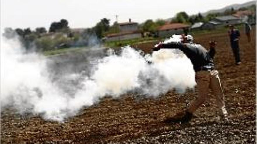 Un refugiat llança de tornada una bomba de gas lacrimogen.