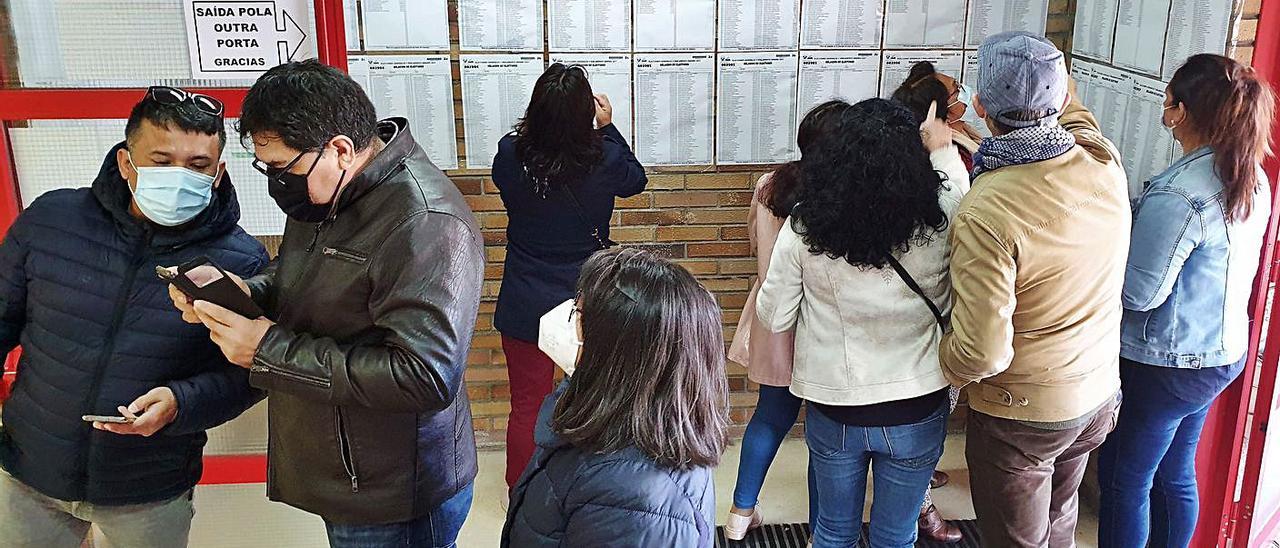 Varios peruanos consultan las listas para la votación, ayer, en el Pabellón de O Berbés. |   // MARTA G.BREA