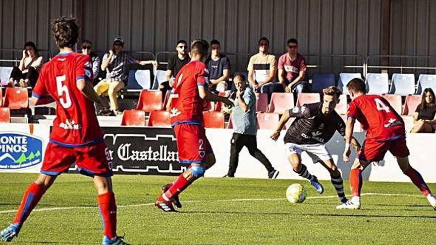 Valentín se interna en el área defendida por los jugadores del Numancia B.