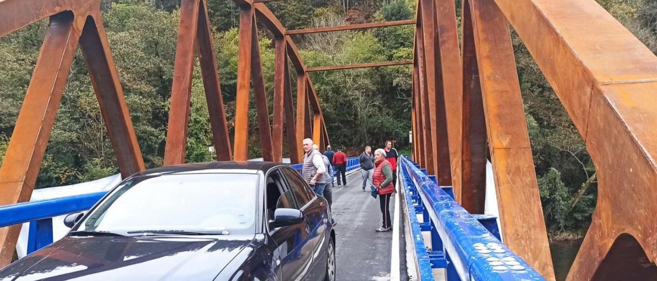 Un vehículo y varios vecinos, estrenando ayer el nuevo puente de Quinzanas. | S. Arias