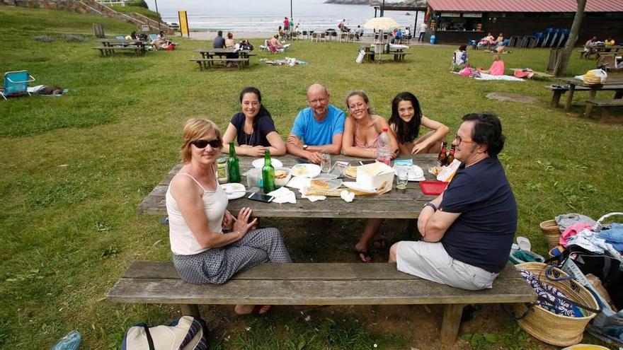 Las familias Gutiérrez-Fernández y Vega-Fernández, de merienda con la playa de Santa María del Mar al fondo.