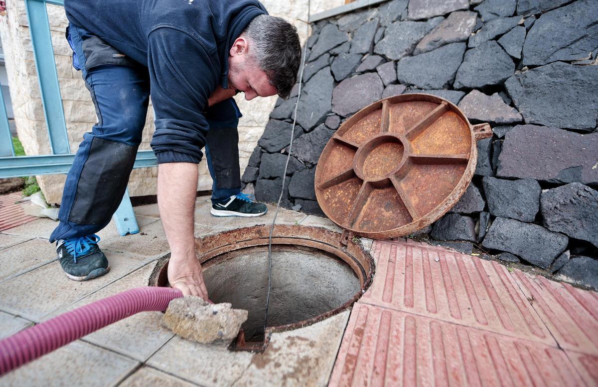 Un hombre achica el agua de la red de alcantarillado de Anaga.