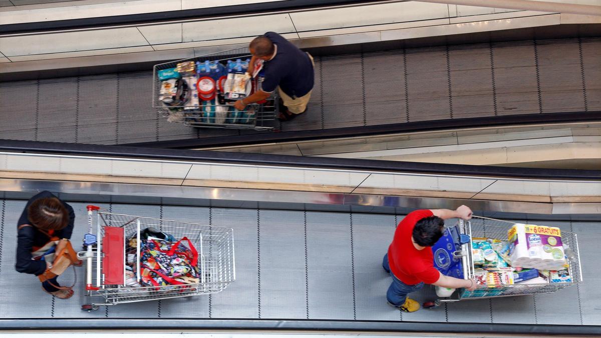 Clientes de un comercio con sus carritos tras hacer la compra