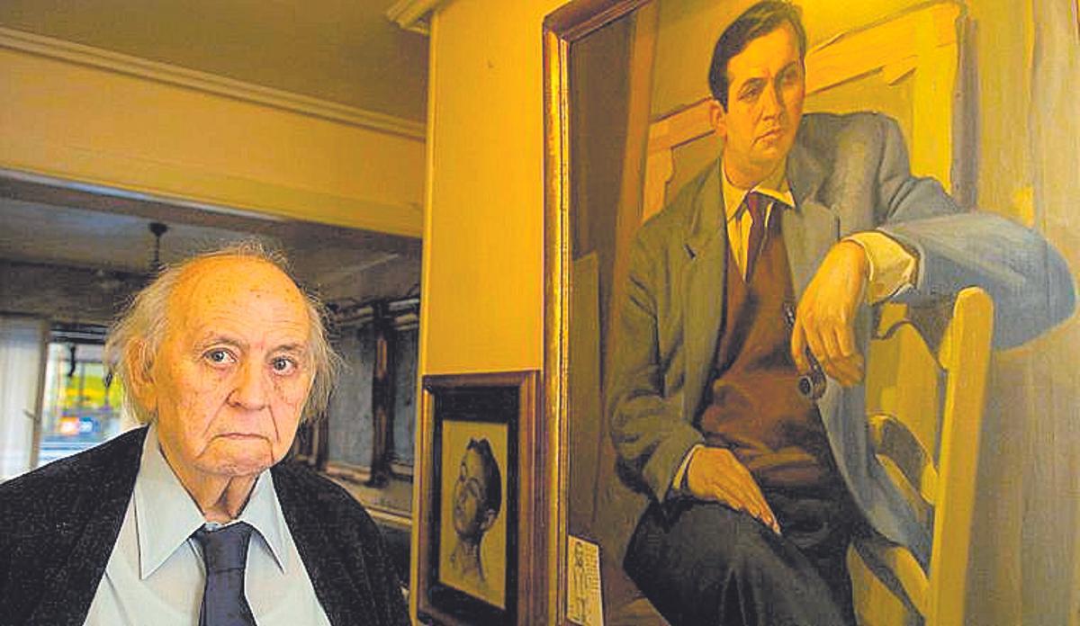 Enrique Serrano en su casa, a los 80 años, ante el retrato que le pintó su padre cuando rondaba los 40.