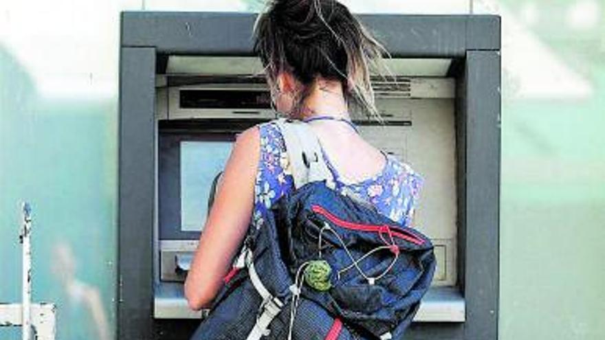 Una mujer saca dinero en un cajero automático. | LOZ