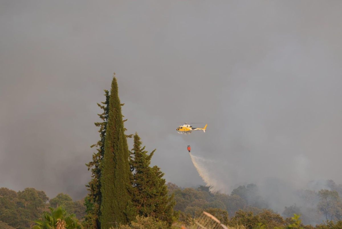 Un helicóptero del Infoex descarga agua sobre la zona incendiada en Malas Aradas en Badajoz.