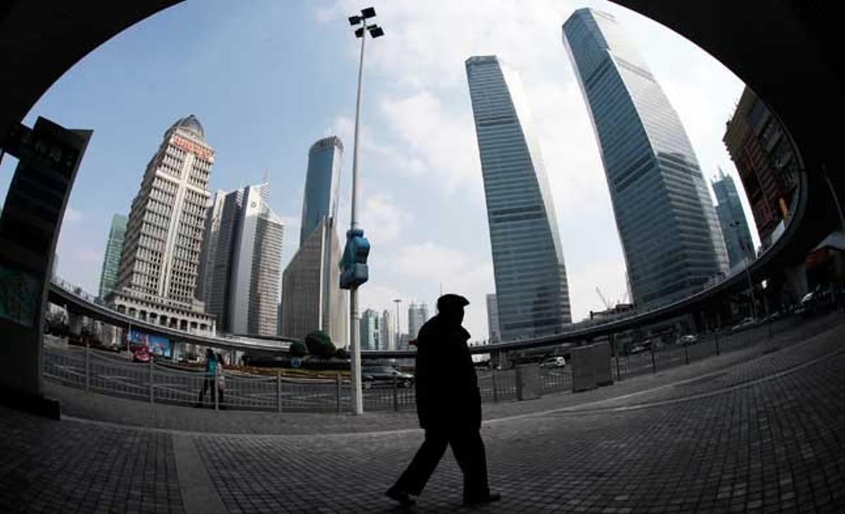 En aquesta foto feta amb un lent ull de peix, un home passa per una zona de gratacels a Xangai, Xina.