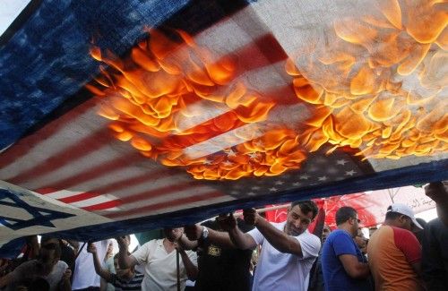 Manifestantes libaneses y palestinos incendiaron banderas estadounidenses e israelíes durante una manifestación para denunciar los ataques aéreos israelíes en la franja de Gaza, en el sur de la ciudad de Líbano.