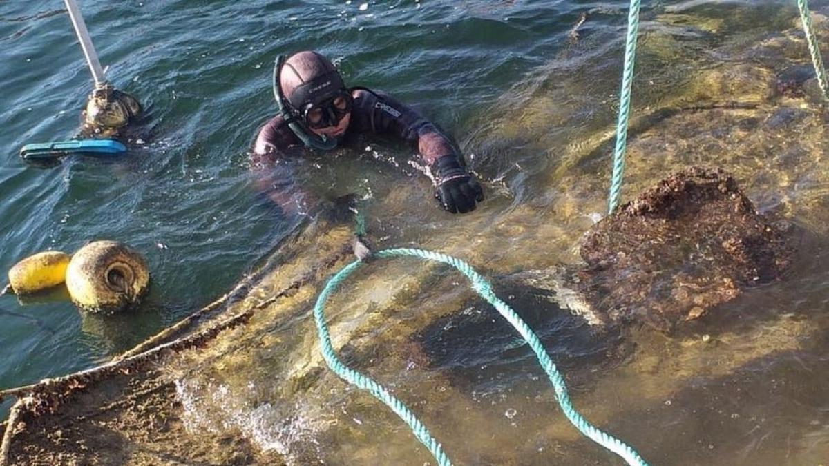 Un buzo junto a una embarcación abandonada en el Mar Menor.