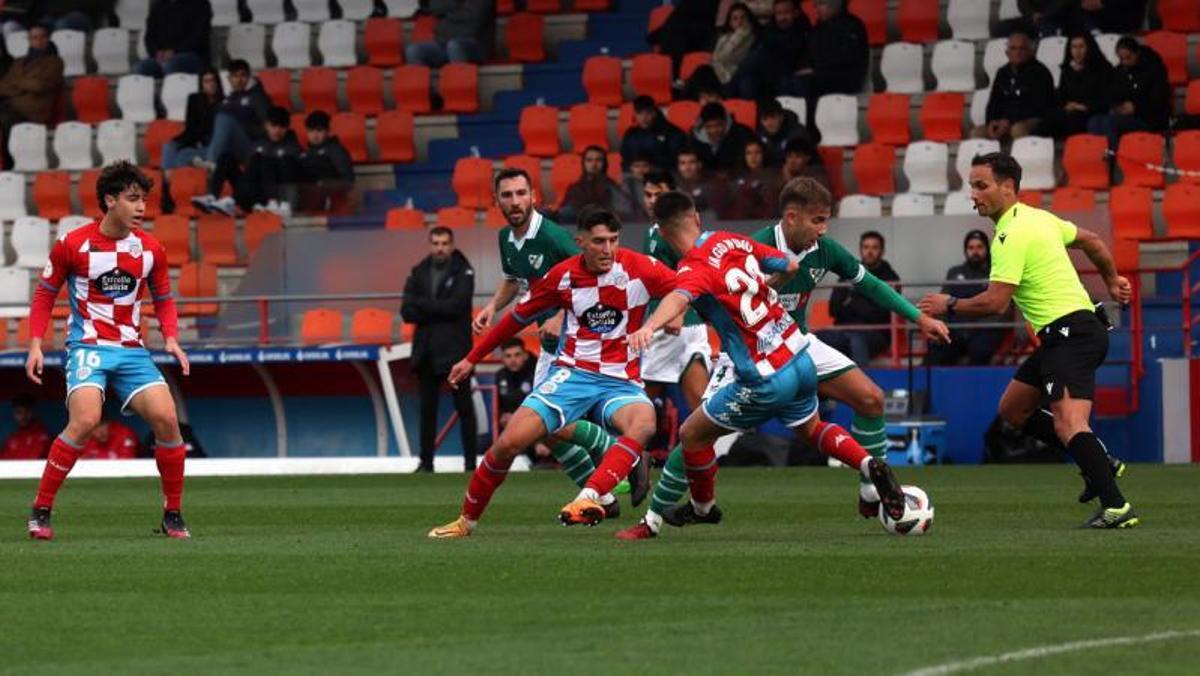 Gandoy, del Coruxo, intenta eludir la entrada de un jugador del Polvorín. |  // EL PROGRESO