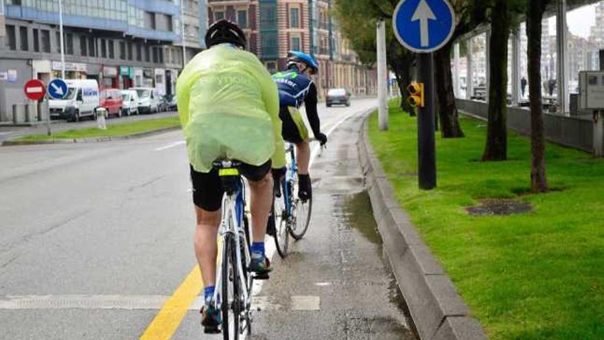 Dos ciclistas, ayer, en la parte en la que se estrecha de repente el carril bici del Muro.