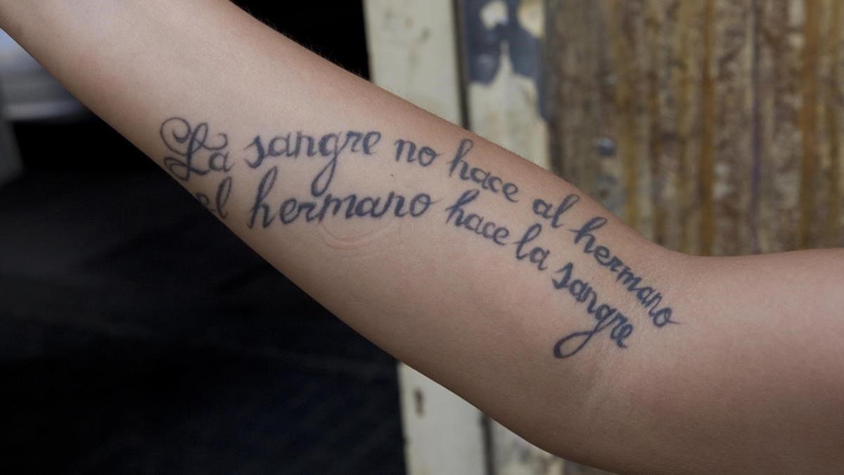 Una frase tatuada en un brazo.