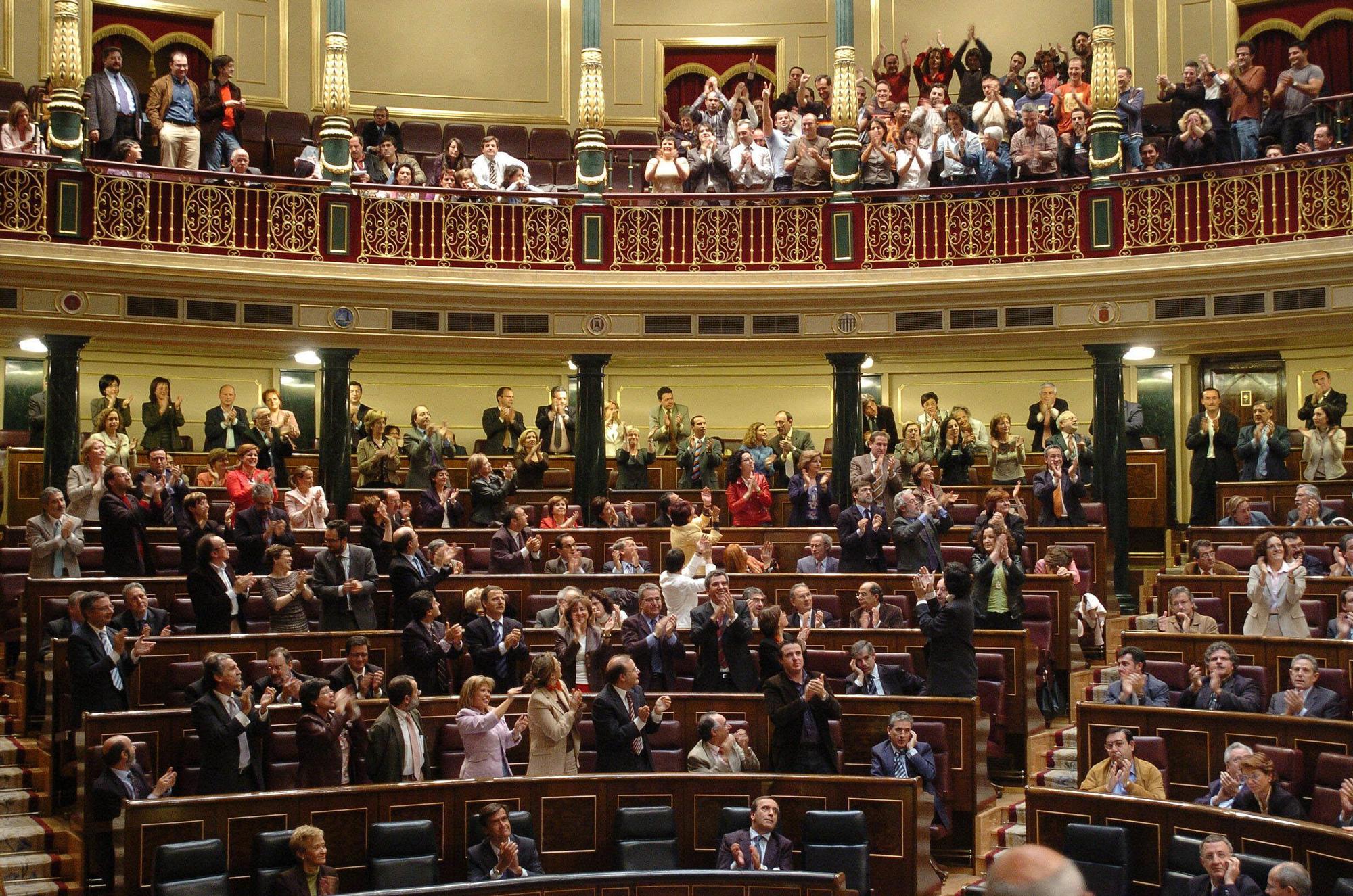 Los diputados socialistas y los colectivos de gays y lesbianas (en la tribuna, arriba) aplauden en el Congreso de los Diputados tras la votación con la que se aprobó el proyecto de ley que permite el matrimonio de personas del mismo sexo en el verano de 2005.