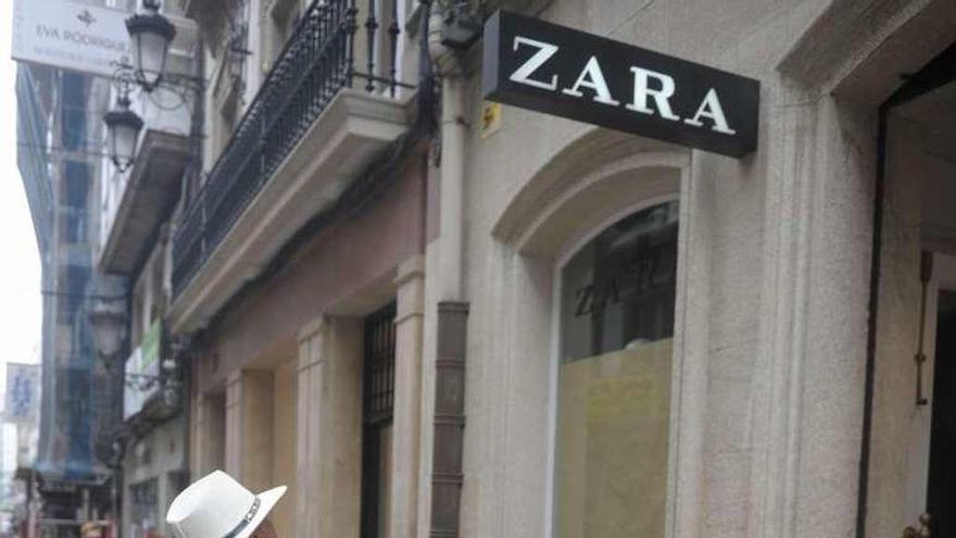Un turista mira una tienda de Zara en la calle Real.