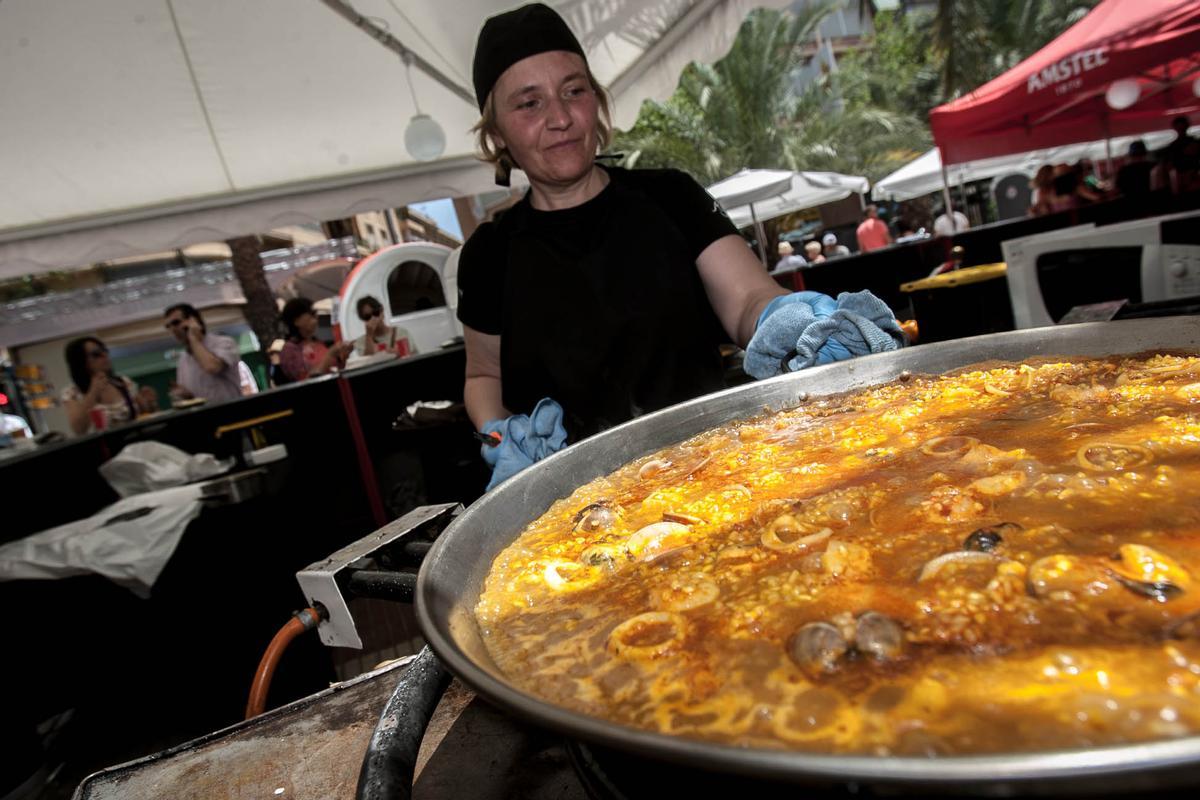 Una cocinera prepara una paella en un racó de Hogueras