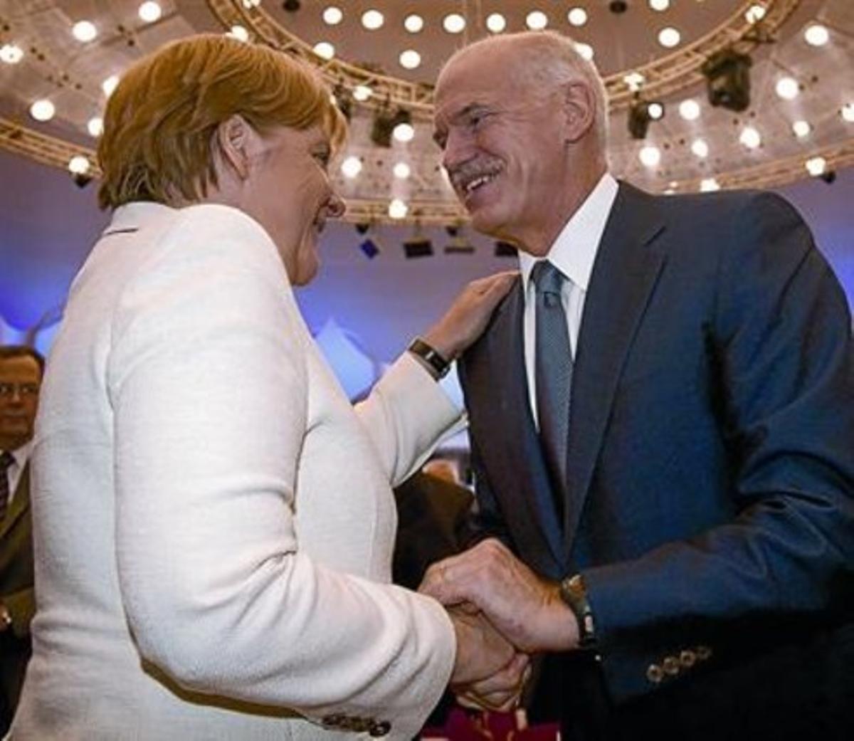 Merkel i Papandreu se saluden, ahir, durant la reunió de la Federació Alemanya d’Indústria, a Berlín.