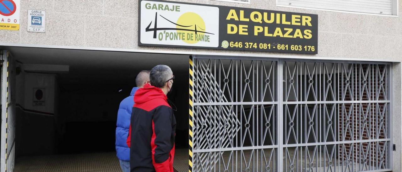 Dos personas pasan por un garaje de Vigo donde alquilan plazas.  // Pablo Hernández