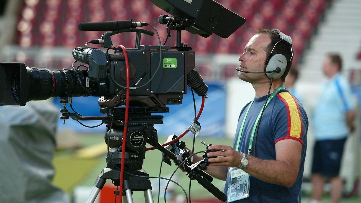 Un operador de cámara trabajando durante un partido de fútbol.