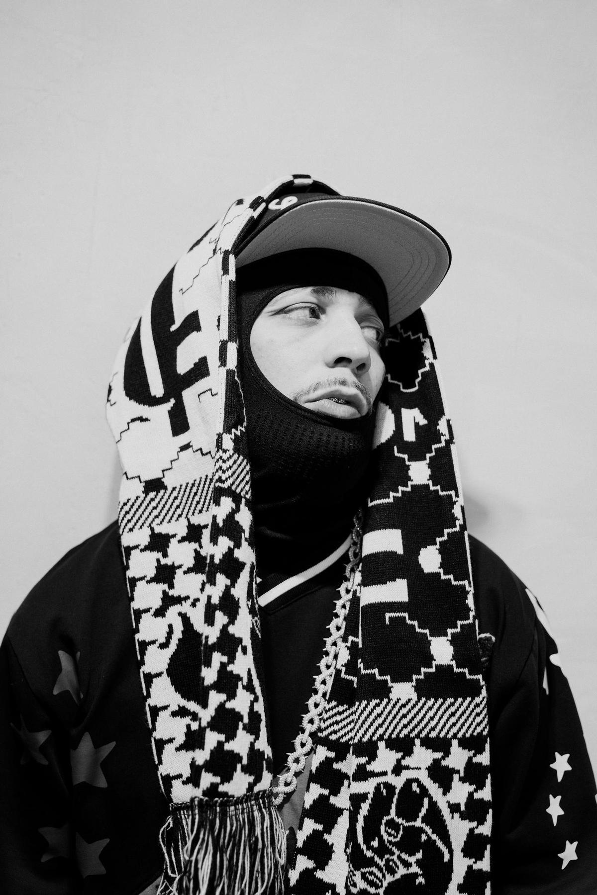 El rapero JC Reyes, ataviado con gorra y bufanda.