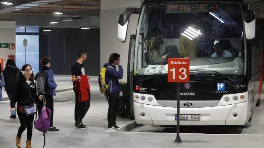 Usuaris pujant a un autobus estacionat a la nova estació de busos de Girona.