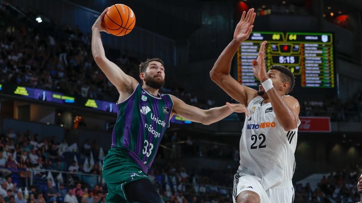 El ala-pívot de Unicaja Killian Tillie (i) entra a canasta ante Walter Tavares, del Real Madrid, durante el primer partido de la semifinal de la Liga Endesa de baloncesto que Real Madrid y Unicaja Málaga disputaron en el Movistar Arena