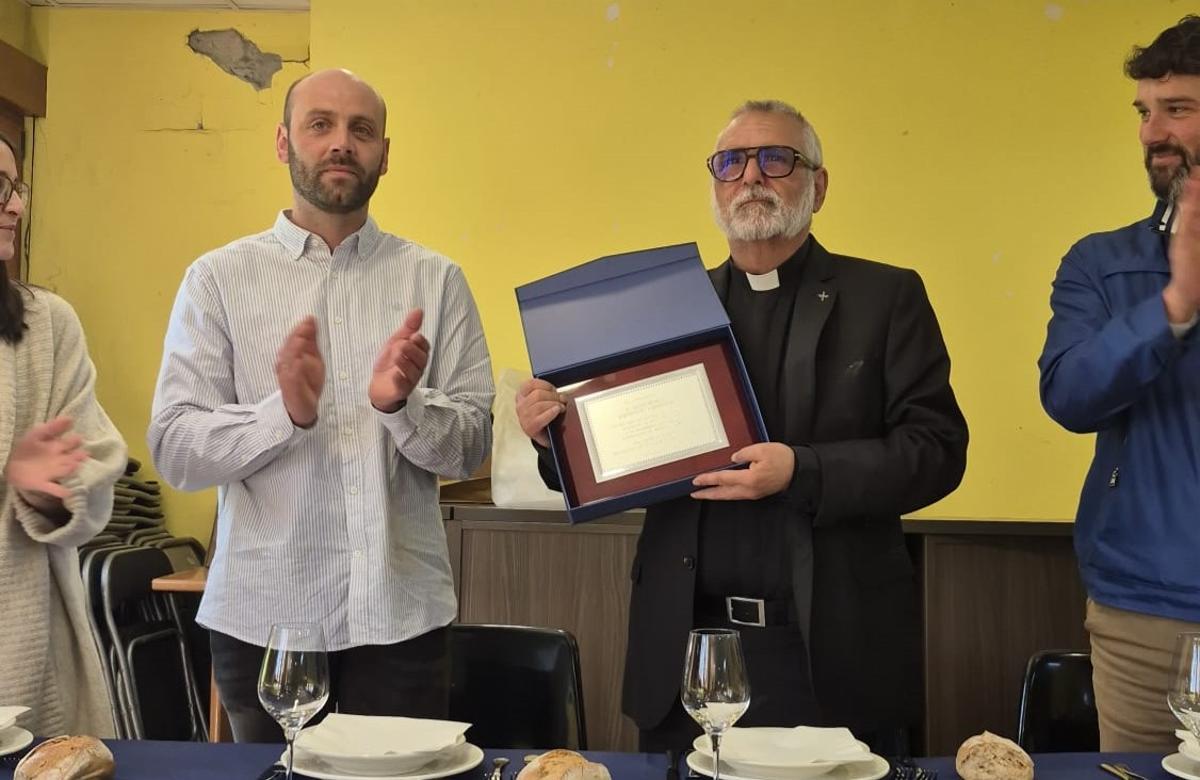 Emilio Menéndez recibe la placa de agradecimiento en presencia de los representantes vecinales y el alcalde valdesano, Óscar Pérez.