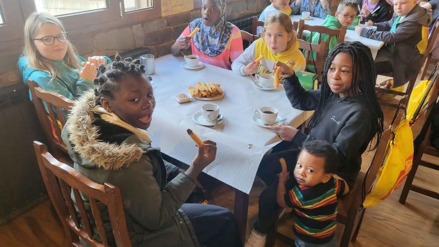 Los escolares ingleses disfrutan de churros con chocolate, a la derecha, una de las clases que los escolares han tomado juntos. | Ch. S.