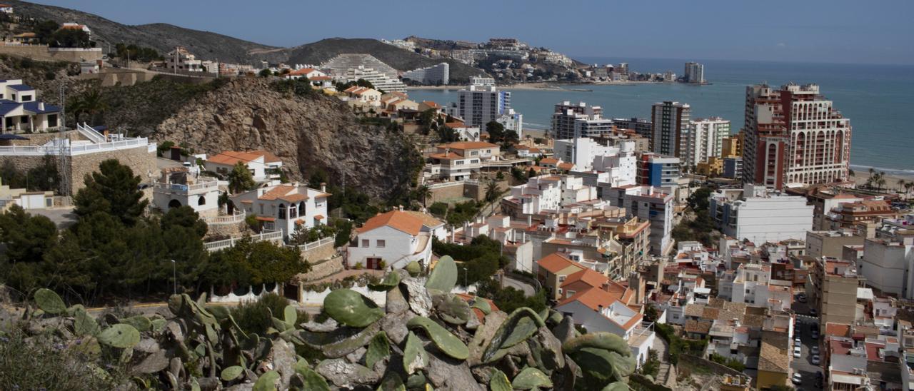 Vista de Cullera desde la montaña, con viviendas en primer plano, apartamentos en segundo y el mar de fondo.