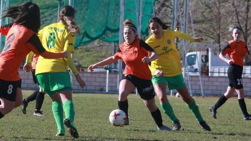 Varias jugadoras de ambos equipos mantienen una lucha cerrada por el esférico.